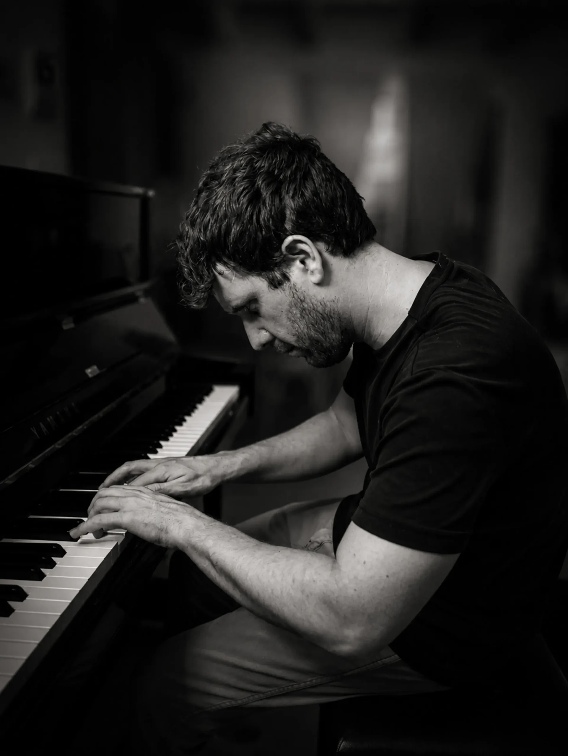 Michele Bargigia ripreso in bianco e nero mentre suona il pianoforte.
