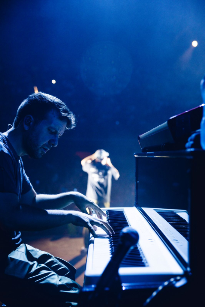 Michele Bargigia al pianoforte durante un concerto con luci blu.