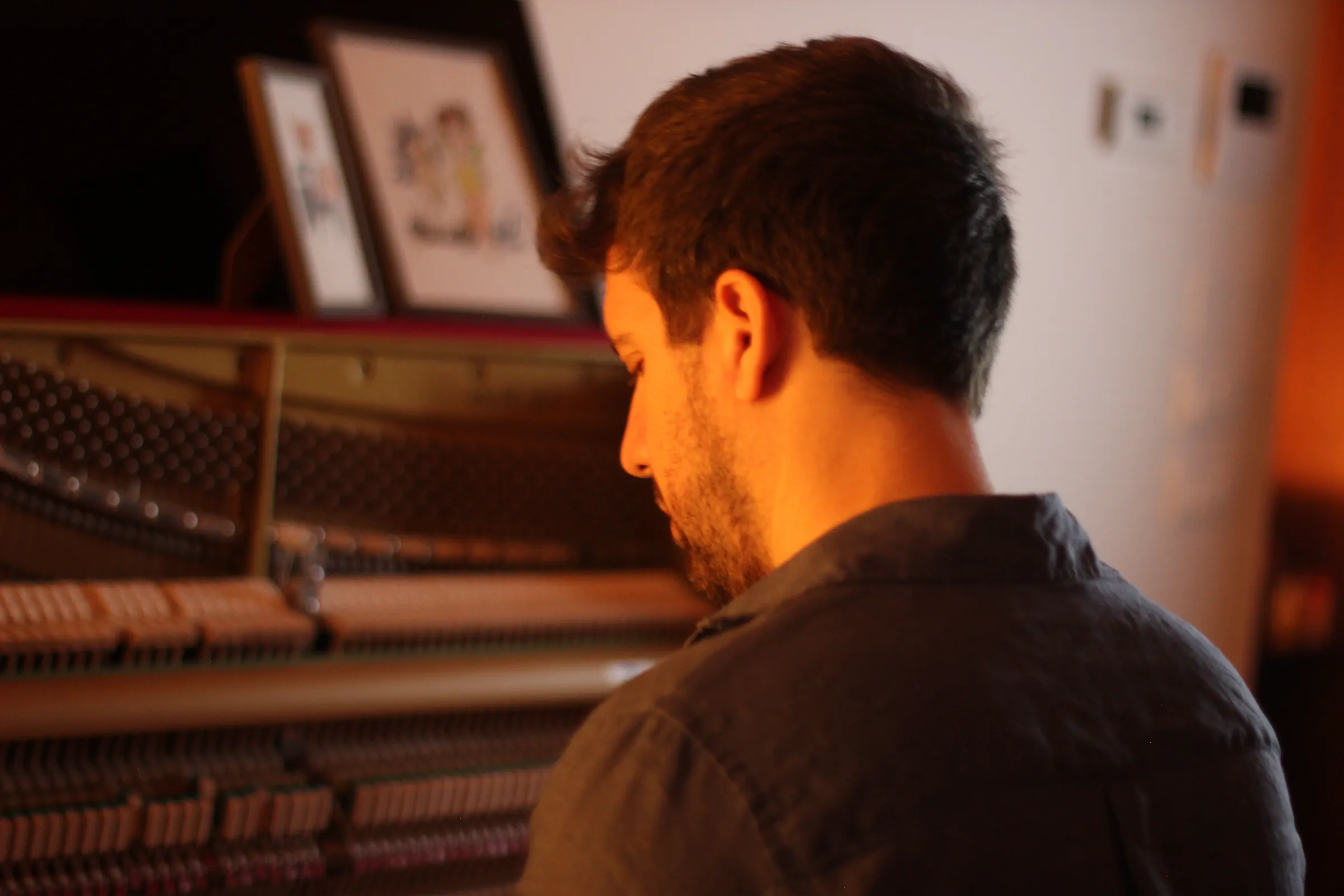 Michele Bargigia accanto al meccanismo interno di un pianoforte verticale.